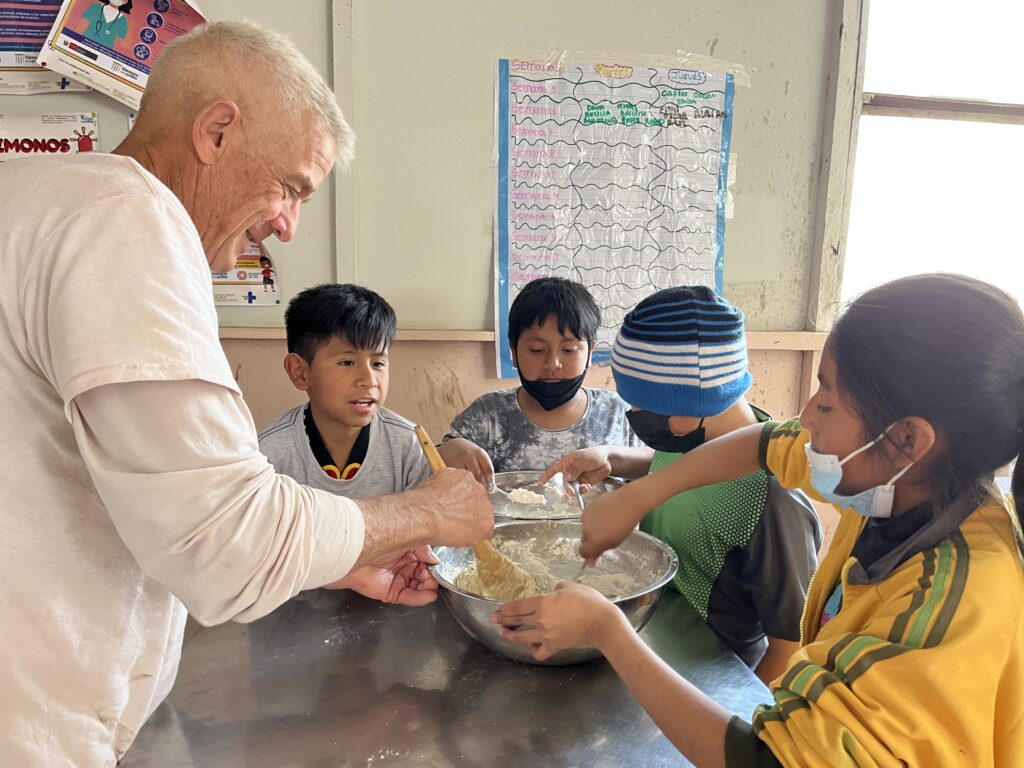 DWC volunteers baking cookies with schoolchildren in Peru