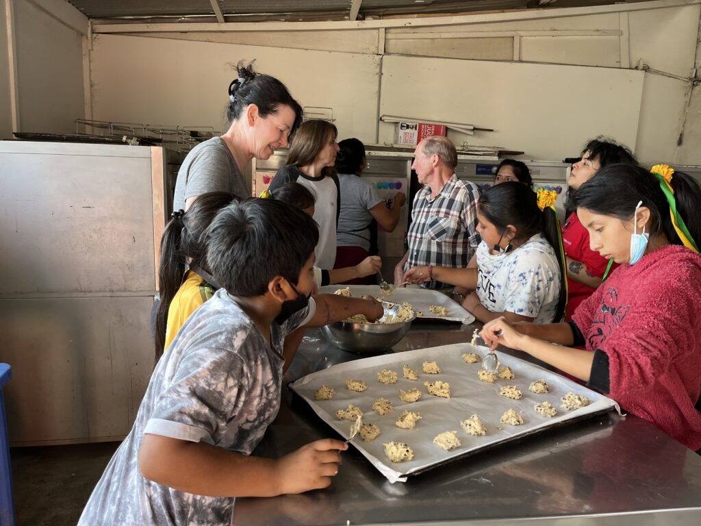 DWC volunteers baking cookies with schoolchildren in Peru