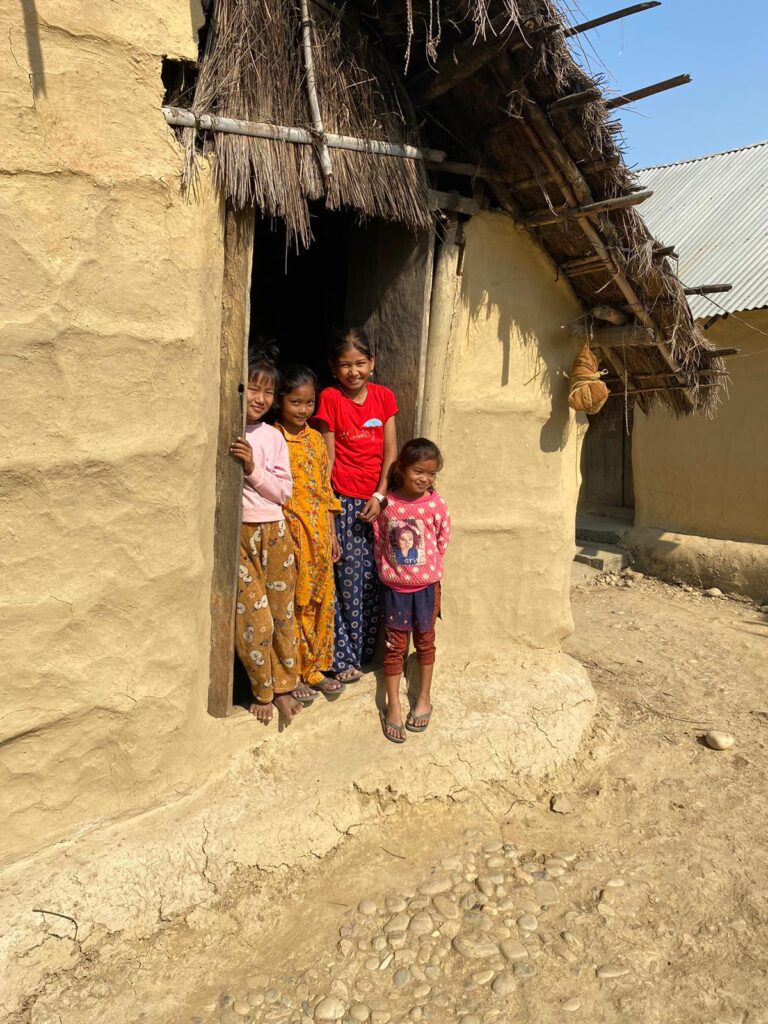 Nepalese children in doorway of home