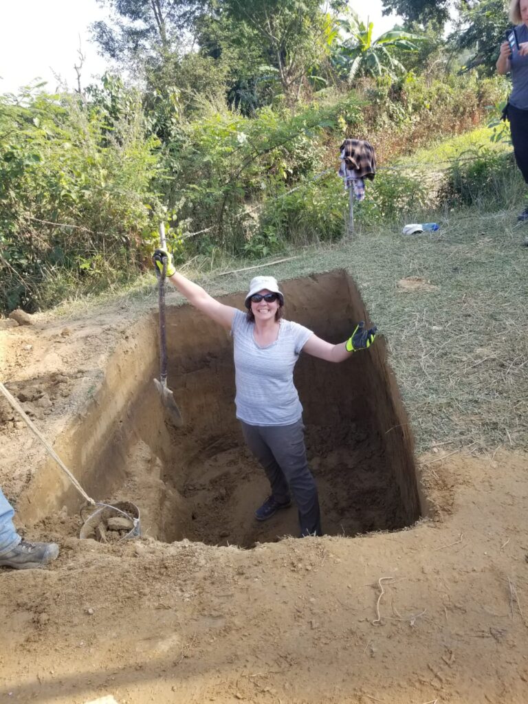 Volunteer in latrine hole Nepal