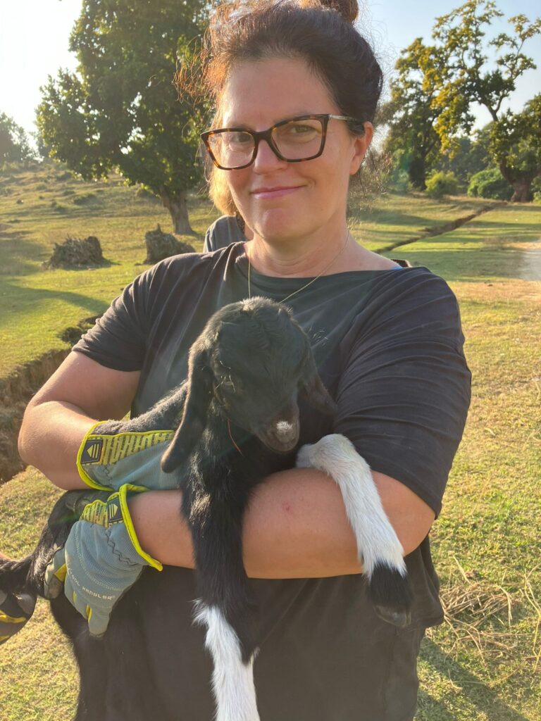 Volunteer holding baby goat Nepal