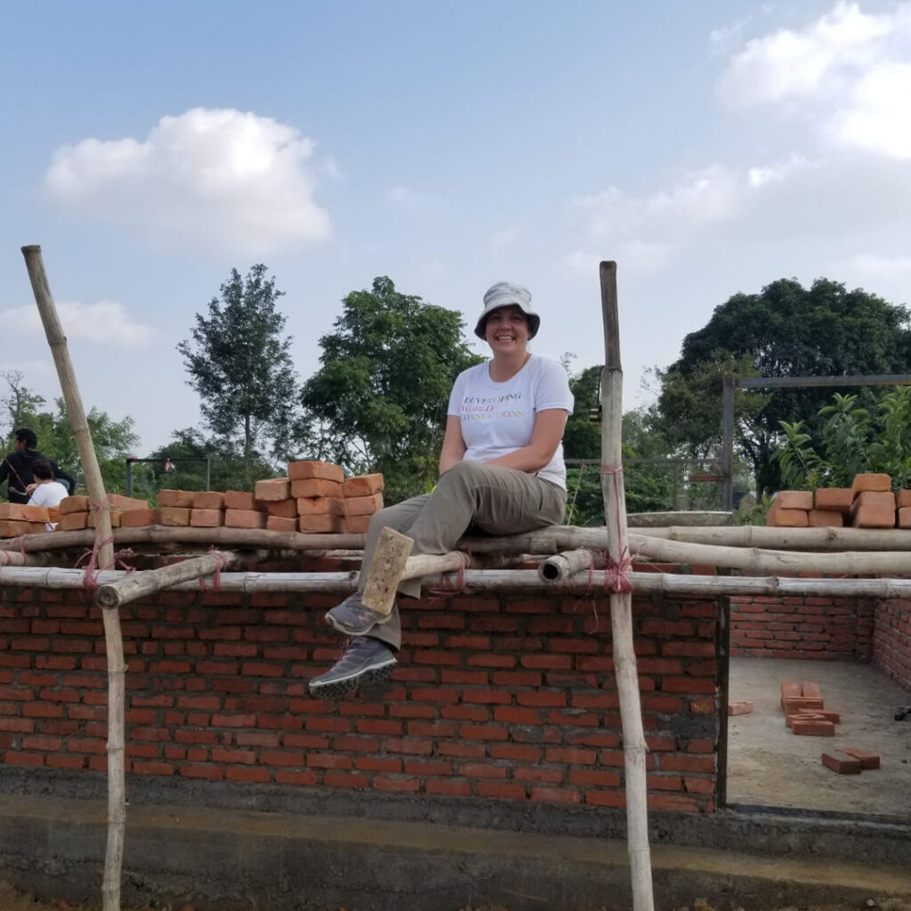 DWC volunteer sitting on bamboo scaffolding