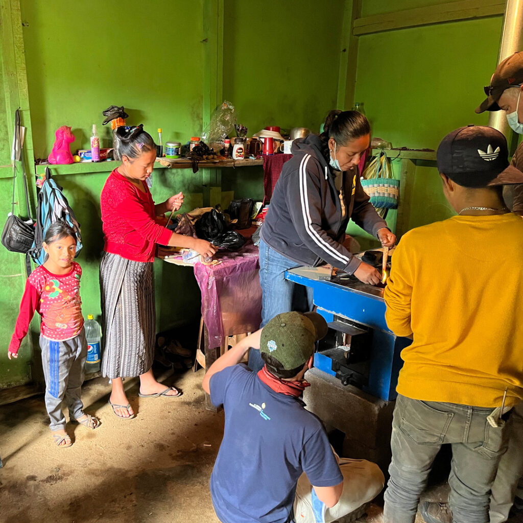 Salesforce volunteers installing stove pipe in home in Guatemala