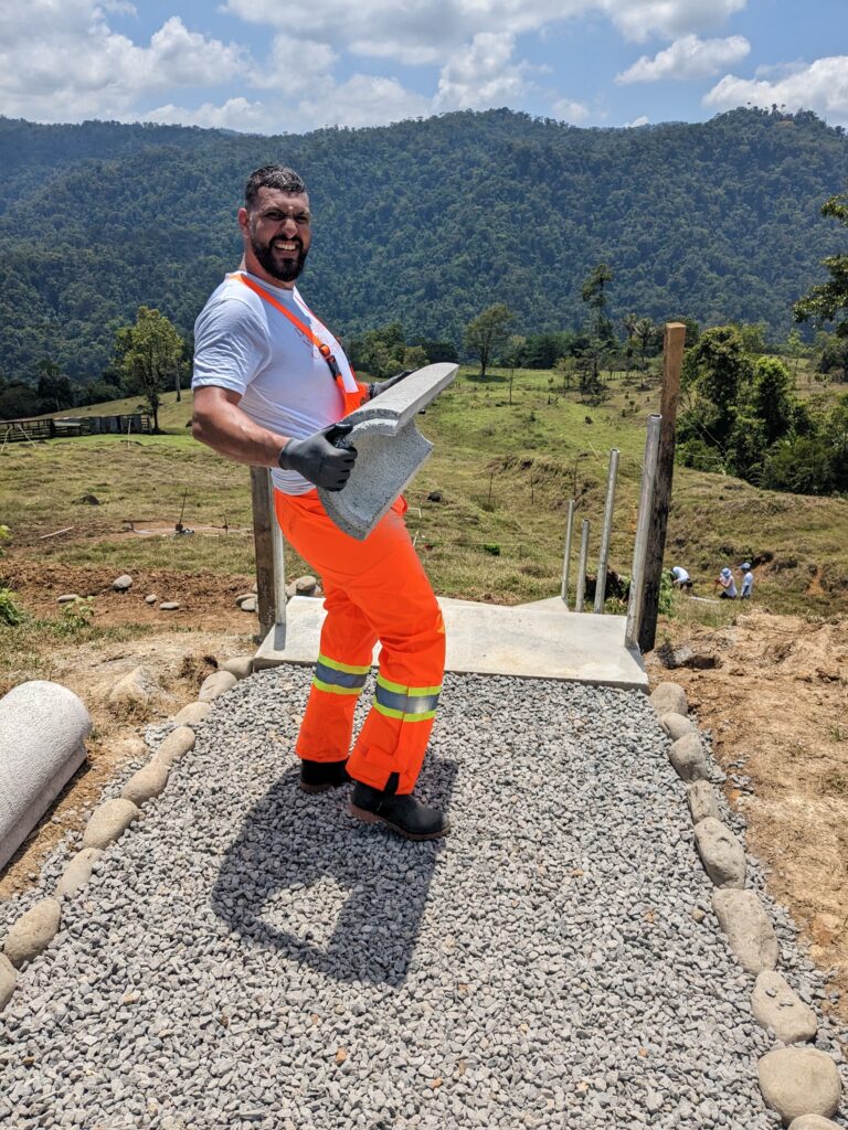 Salesforce volunteer in Costa Rica carrying concrete tube
