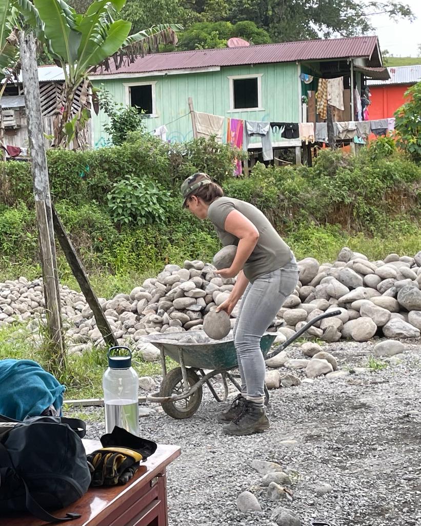 Salesforce volunteer loading rocks into wheelbarrow Costa Rica
