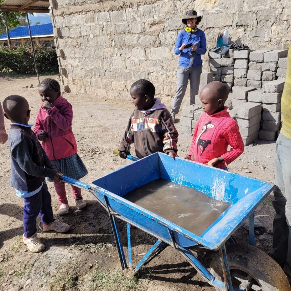 School kids around wheelbarrow in Kenya