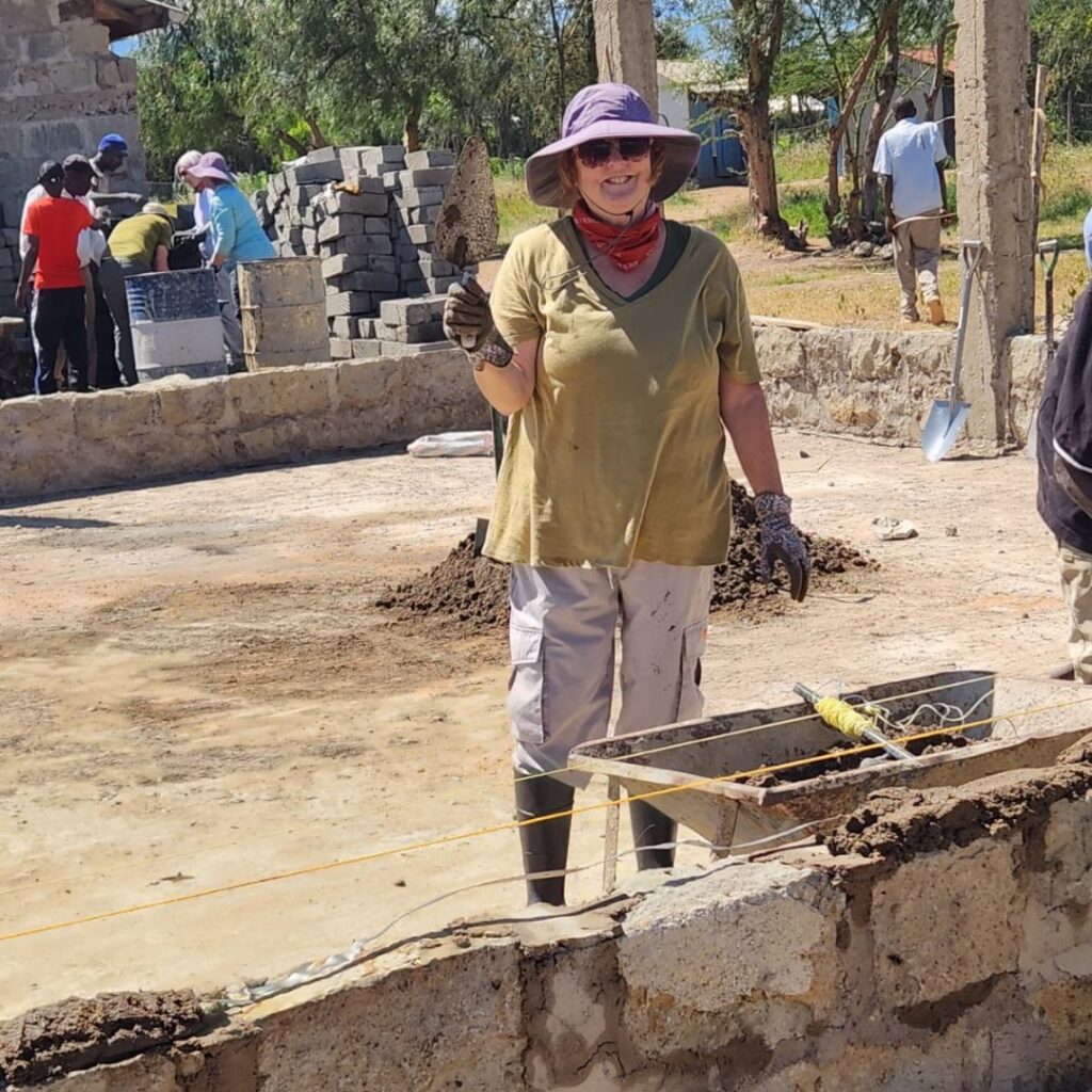 DWC volunteer with concrete trowel in Kenya
