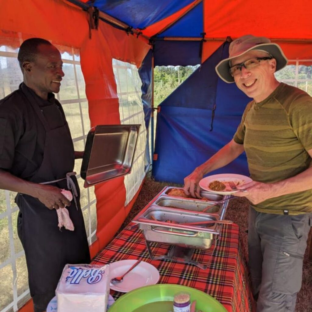 DWC volunteer eating at job site in Kenya