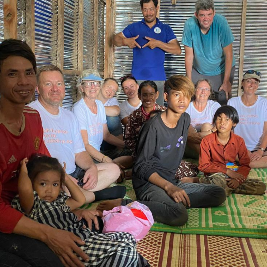 DWC volunteers and local family inside completed house Cambodia