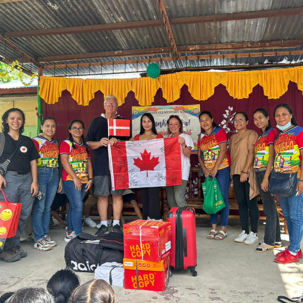 Local Filipinos with DWC Team Leader holding Canada flag