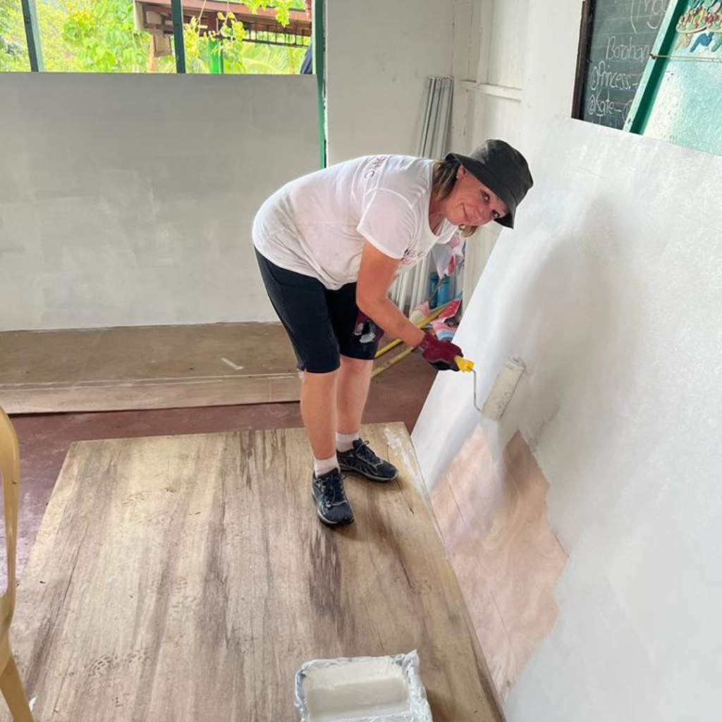 DWC Team Leader painting with a roller at project site in Philippines