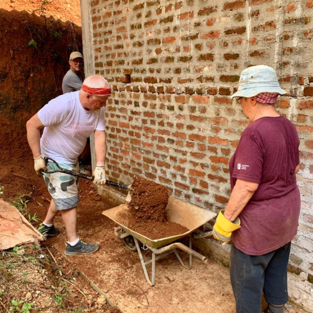 DWC volunteer shoveling dirt into wheelbarrow Sri Lanka