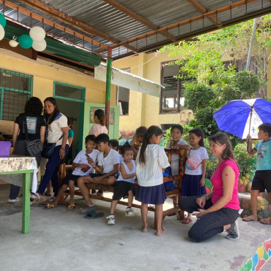 DWC volunteers taking a break with children Philippines