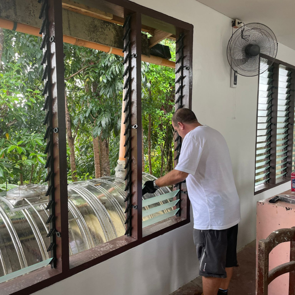 Volunteer installing window glass Philippines