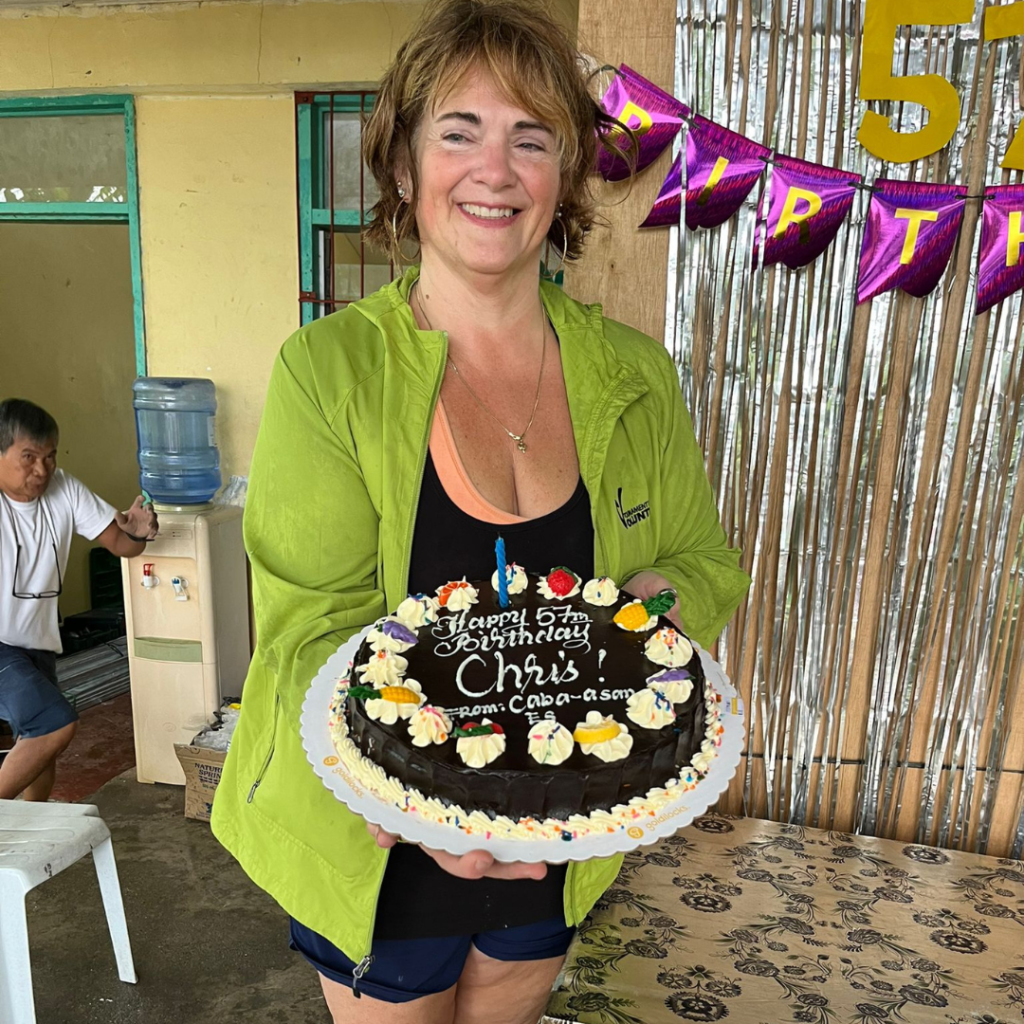 DWC volunteer holding cake at birthday party in Philippines