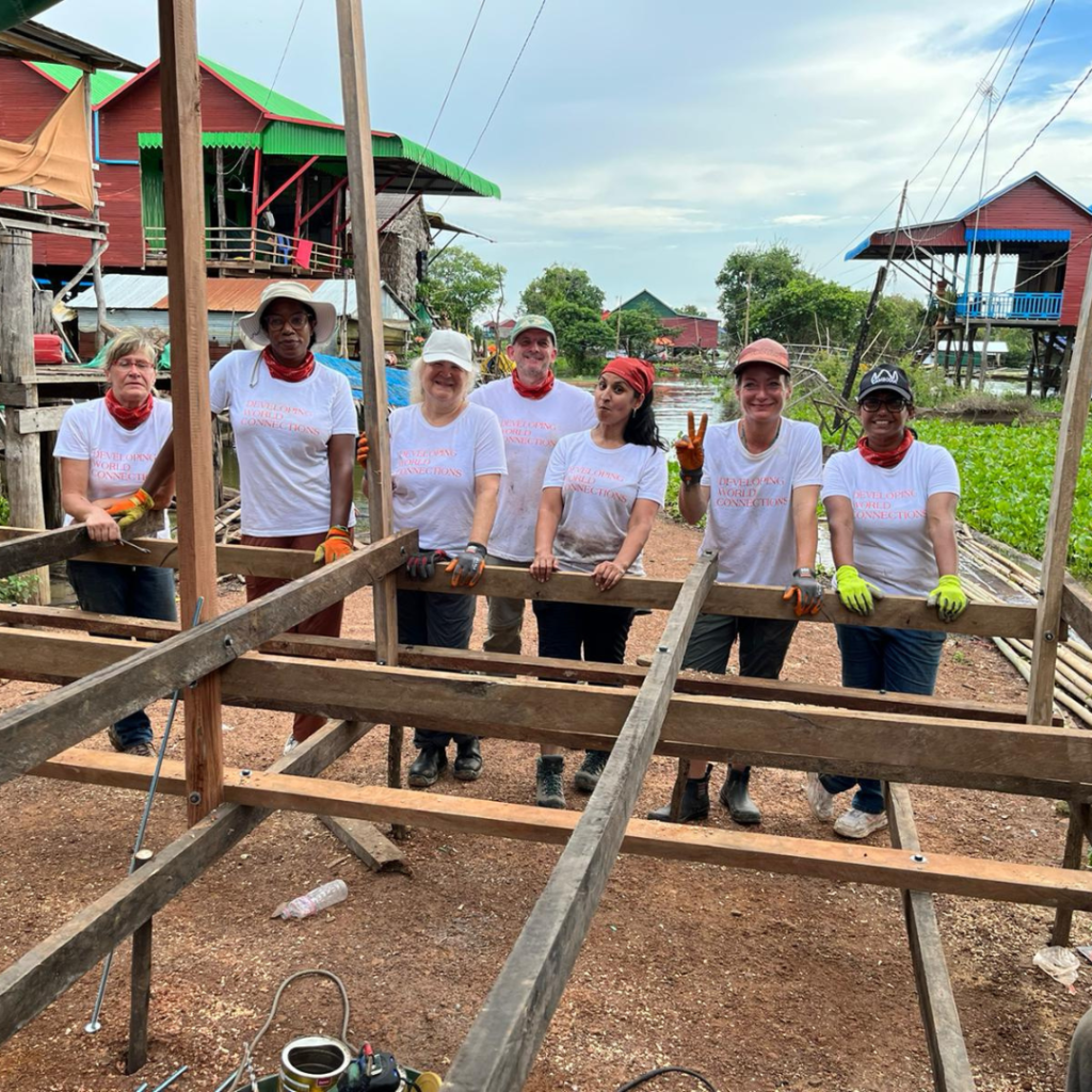Salesforce volunteers in Cambodia posing with construction structure
