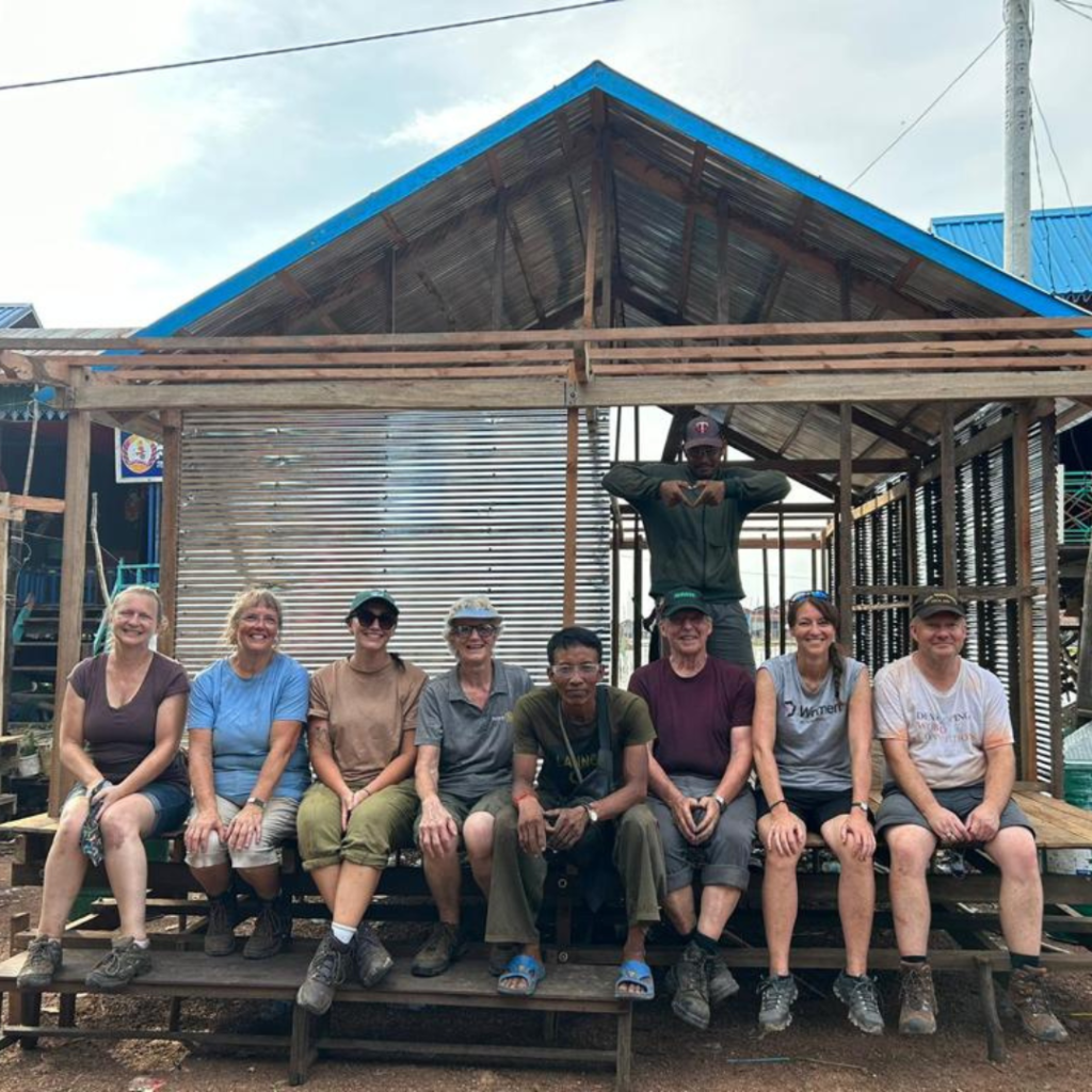 DWC volunteers sitti ng in front of floating home project Cambodia