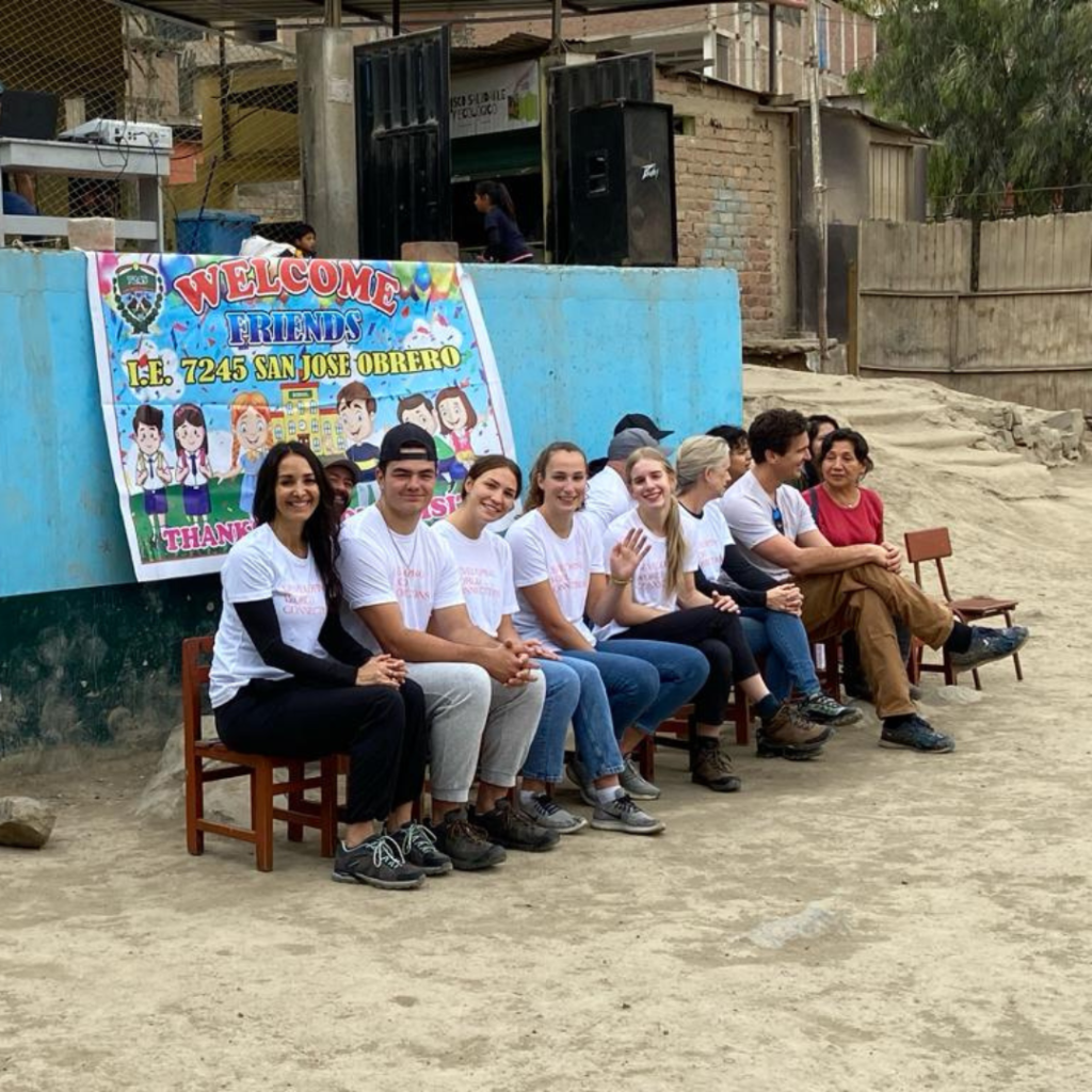 Urban Systems volunteers sitting on chairs outside San José Obrero School Peru