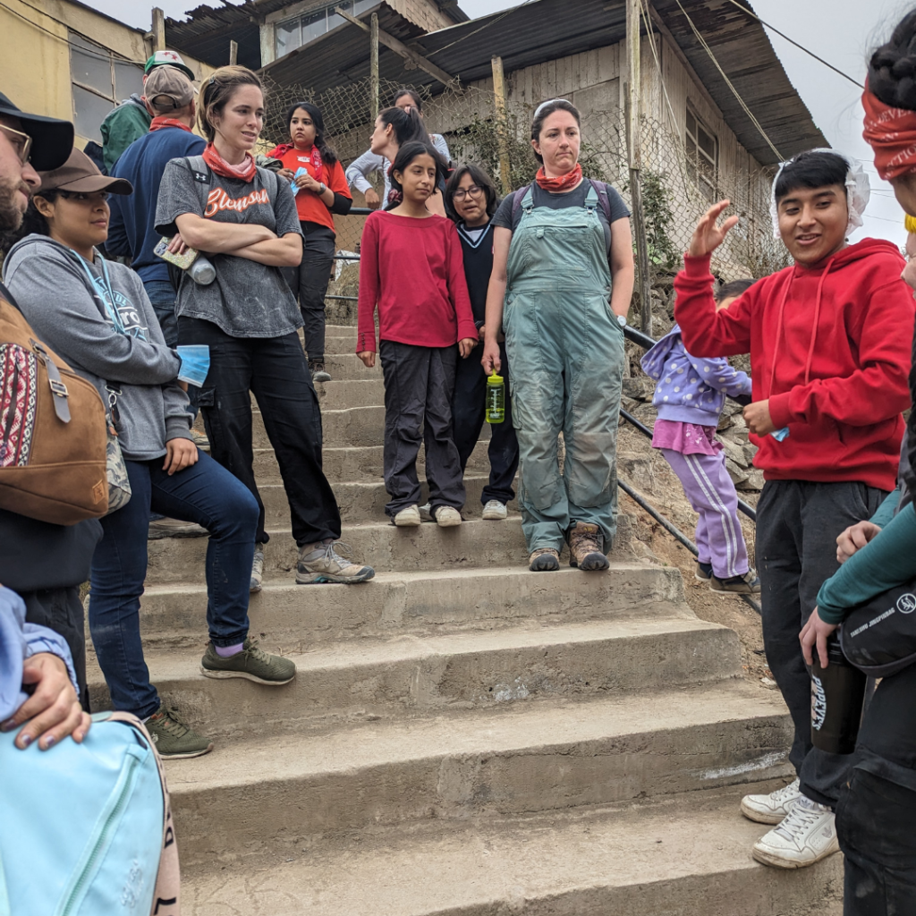 Volunteers and students on staircase at San José Obrero School Peru
