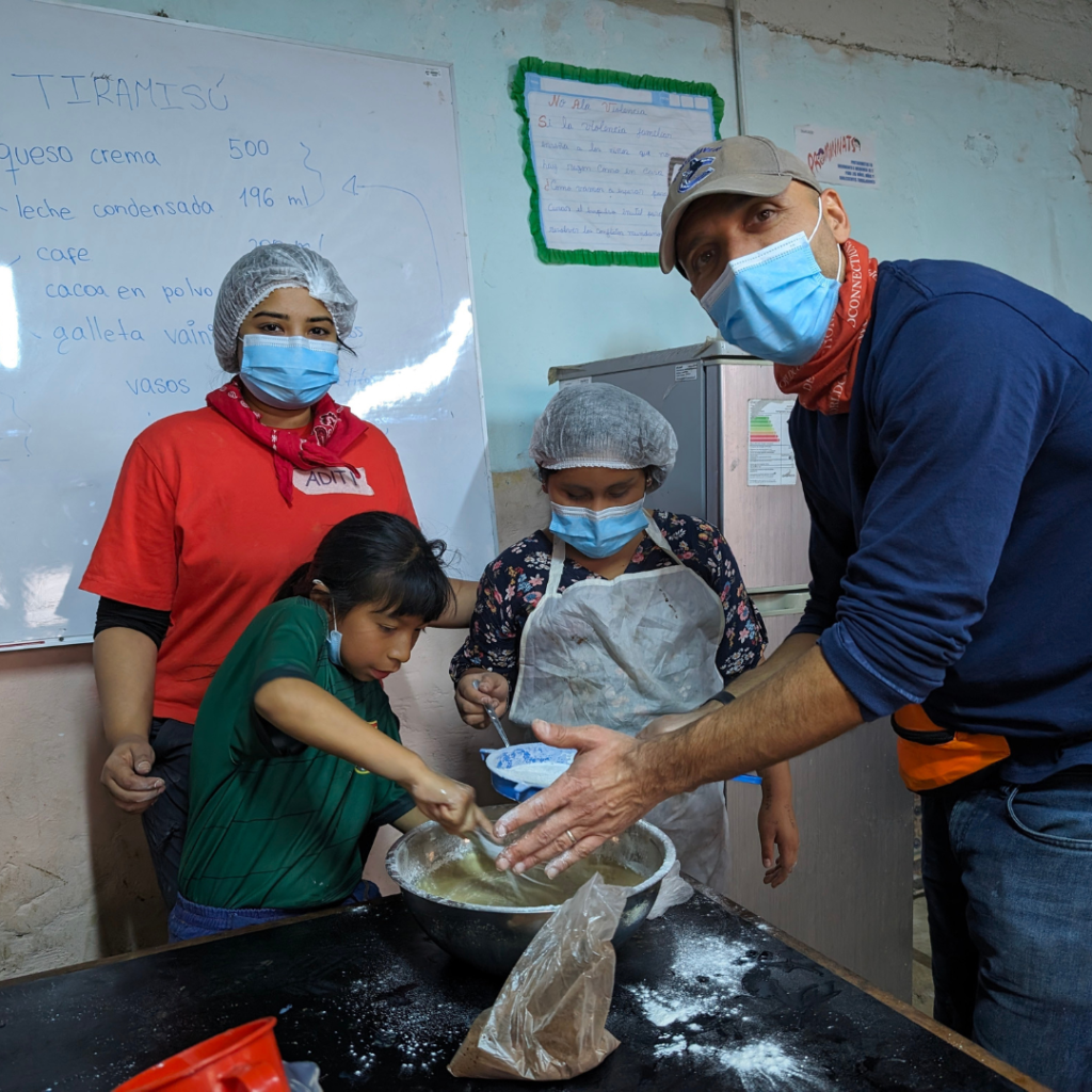 School kids and volunteers in pastry kitchen in San José Obrero School Peru