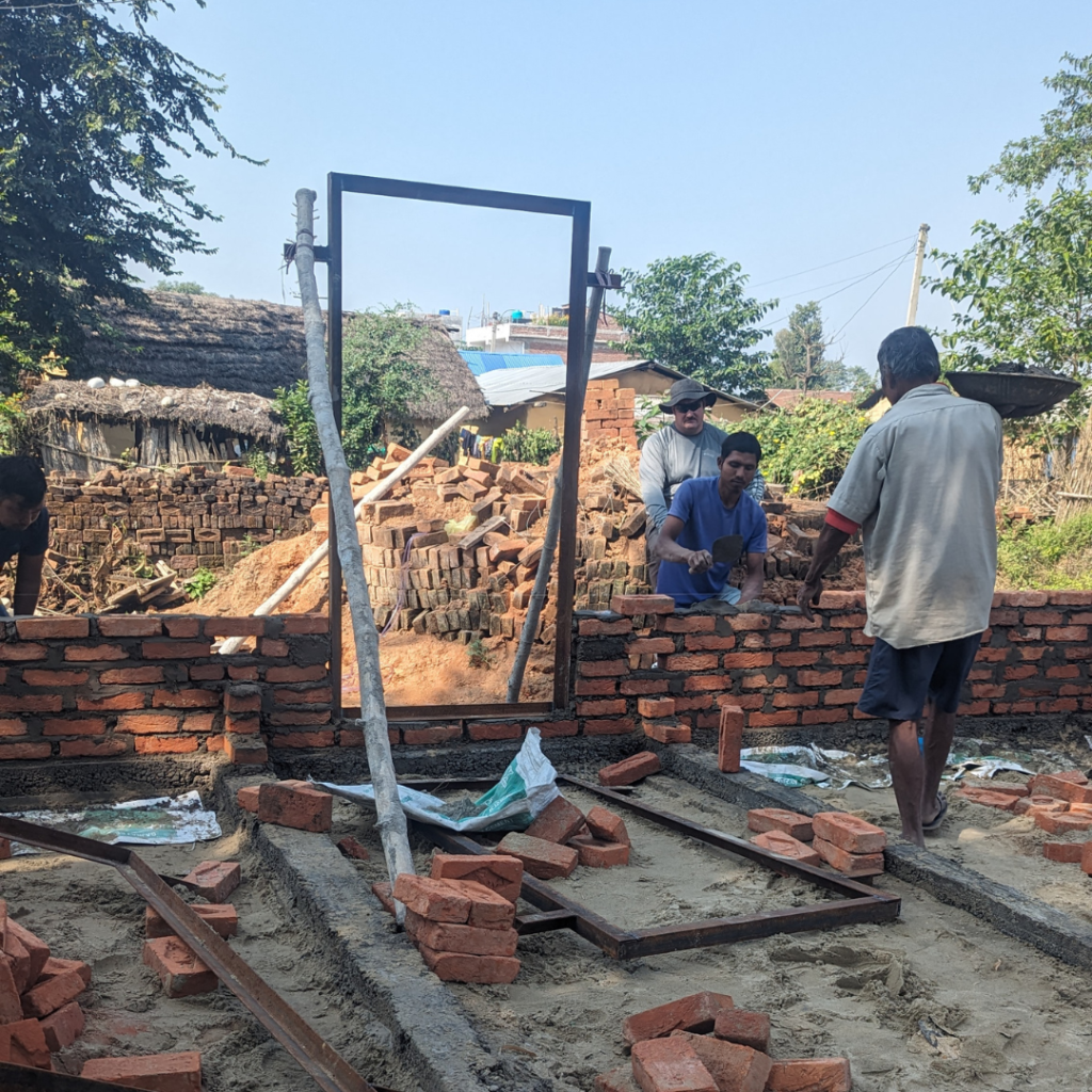 volunteers and locals laying brick Nepal