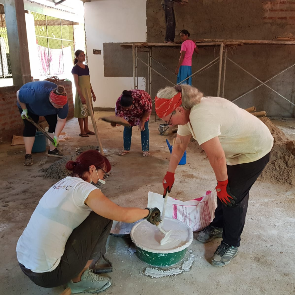 Volunteers in Sri Lanka mixing cement and drywall mud