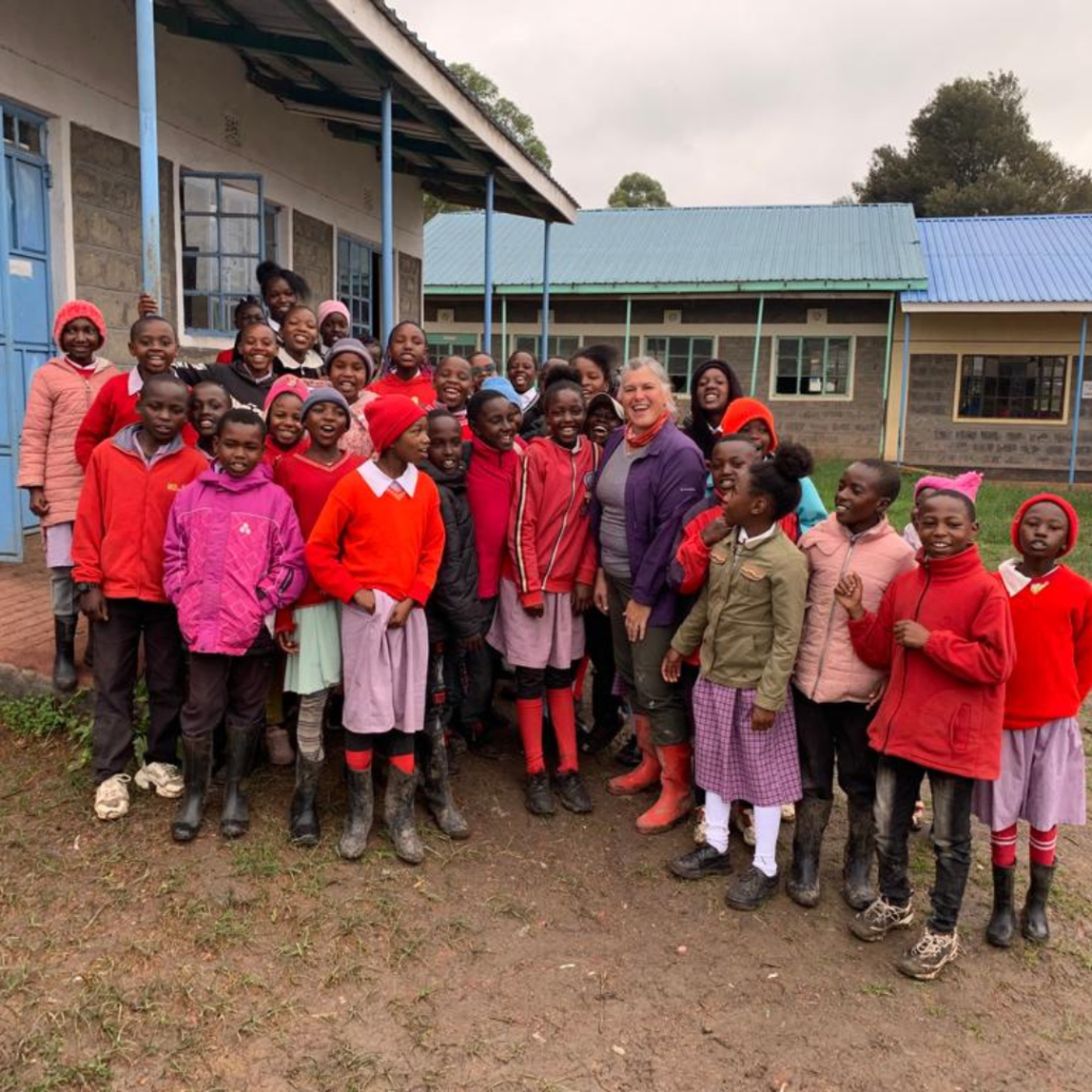Kenya schoolchildren outside classroom with volunteer
