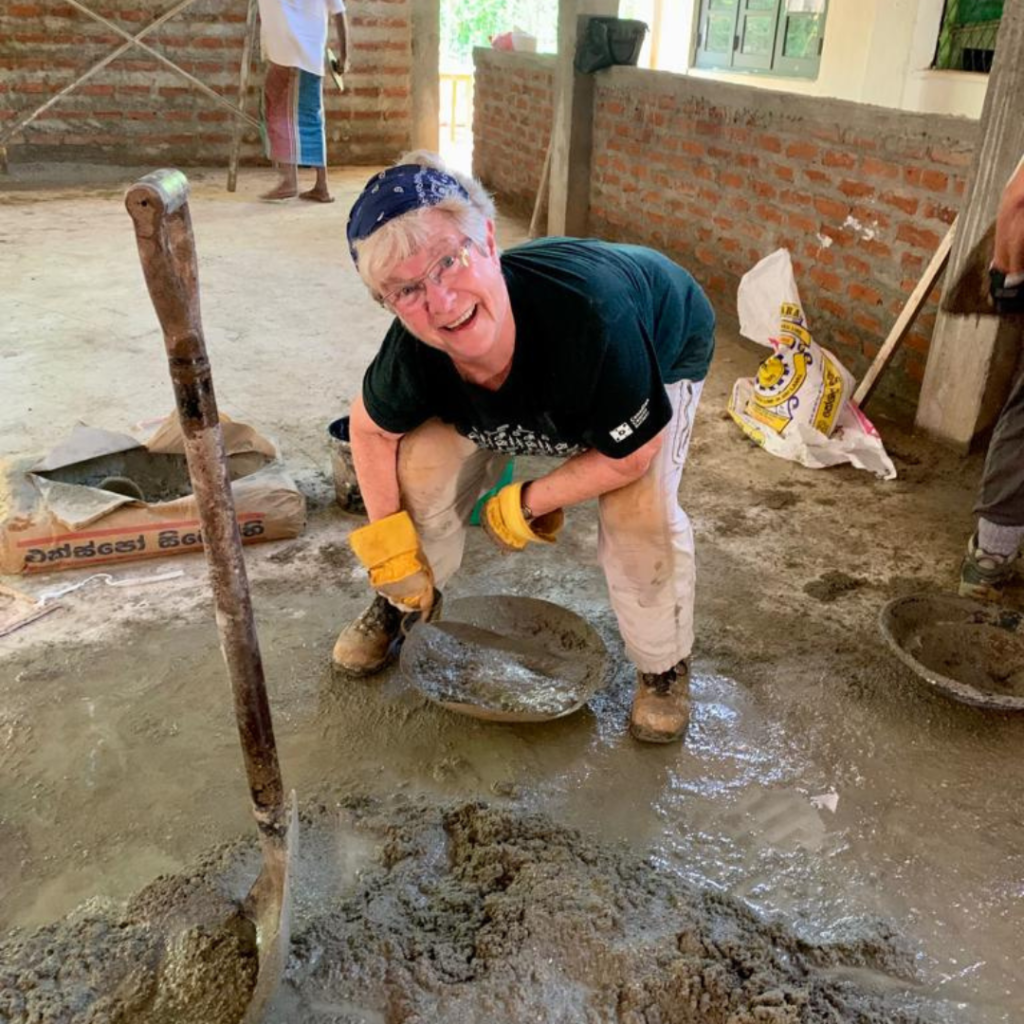 Volunteer in Sri Lanka mixing cement