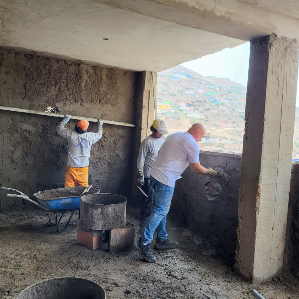 Mudding brisk walls with mortar San José Obrero School Peru