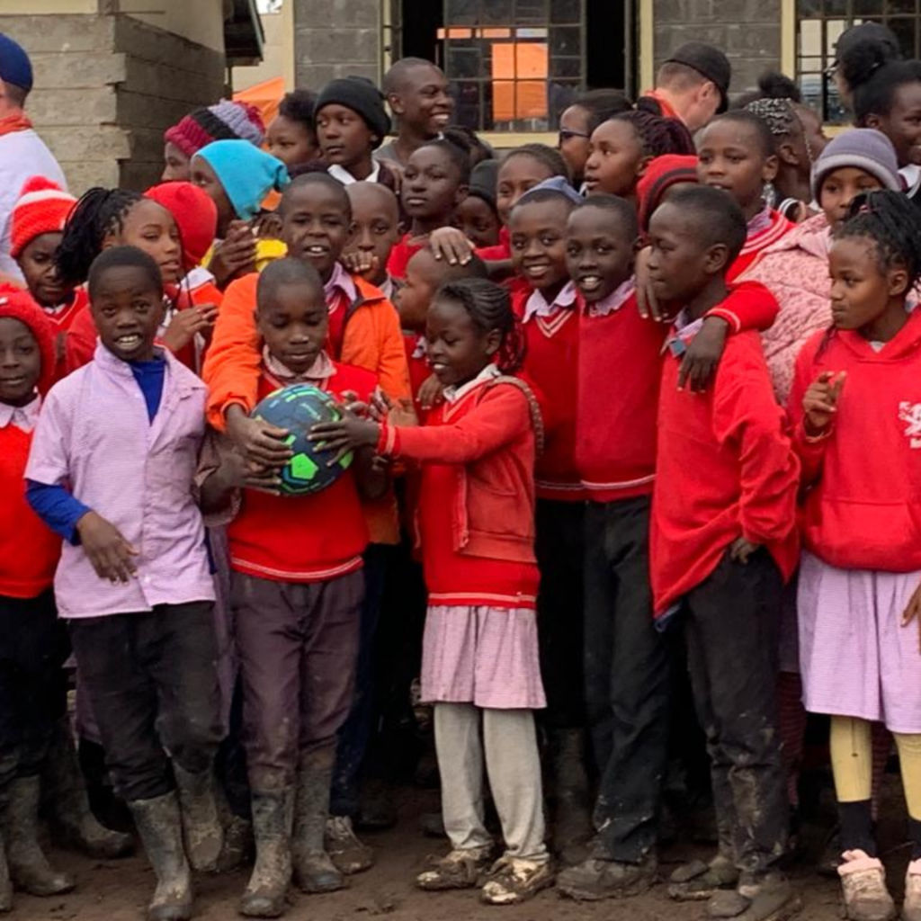 Kenya schoolchildren outside classroom with soccer ball