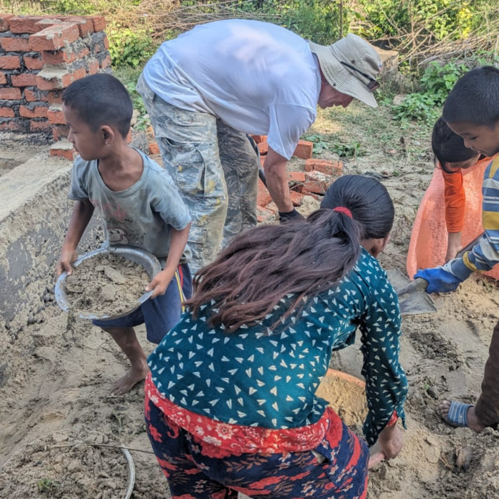 Marty France digging dirt with children Nepal