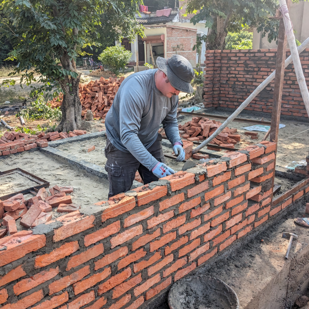 DWC volunteer laying bricks and mortar Nepal
