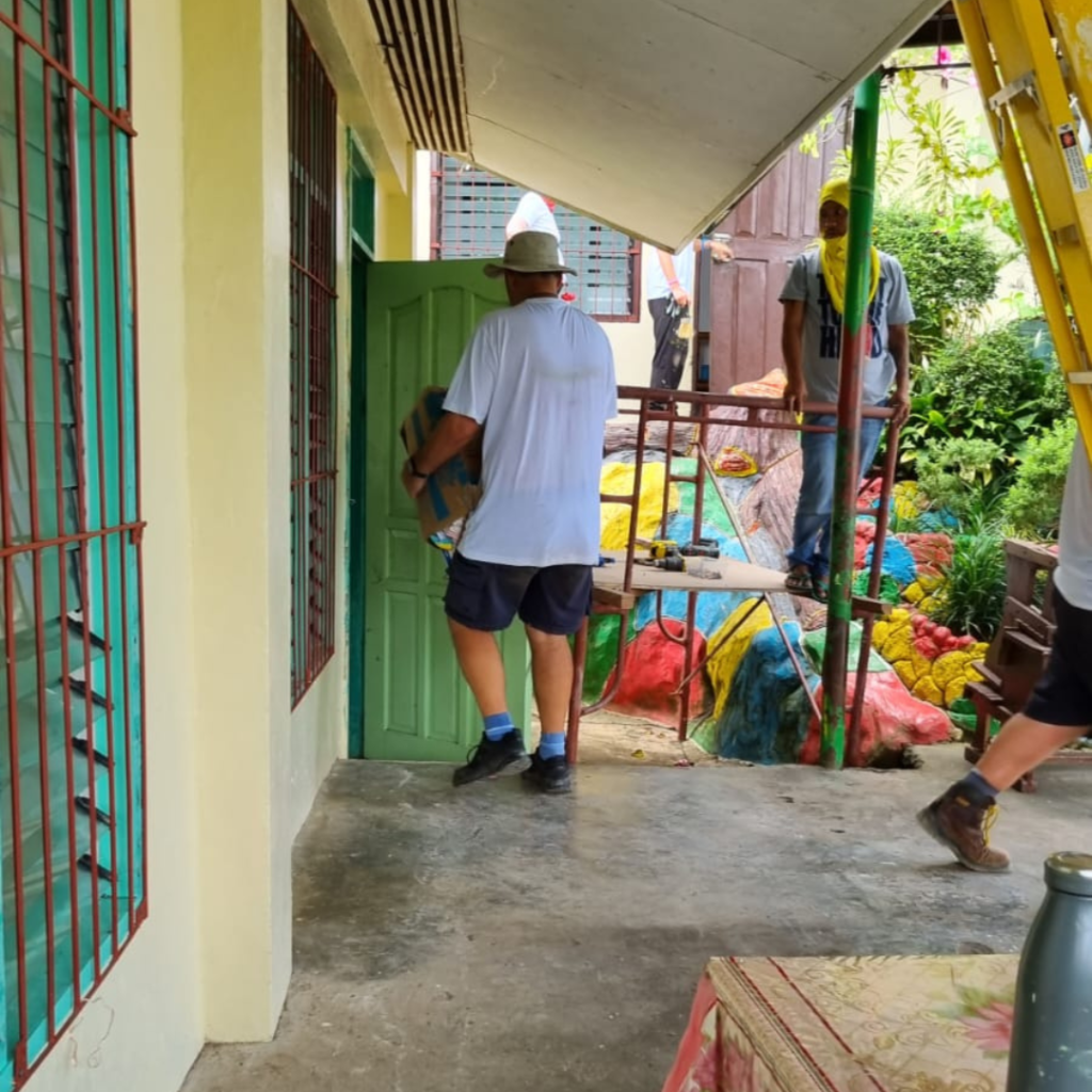 Local on scaffolding outside with DWC volunteer Philippines