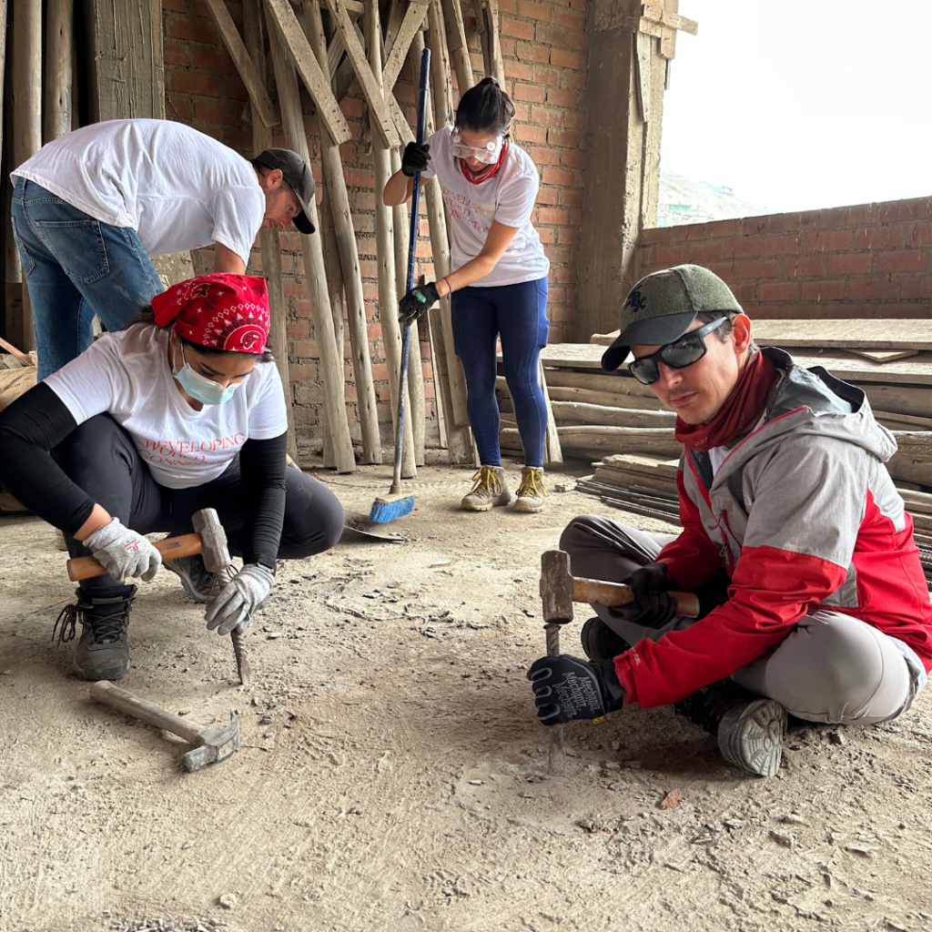 Salesforce volunteer working with hammer and chisel Peru
