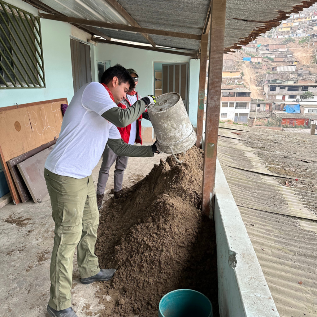Salesforce volunteers unloading buckets of dirt Peru