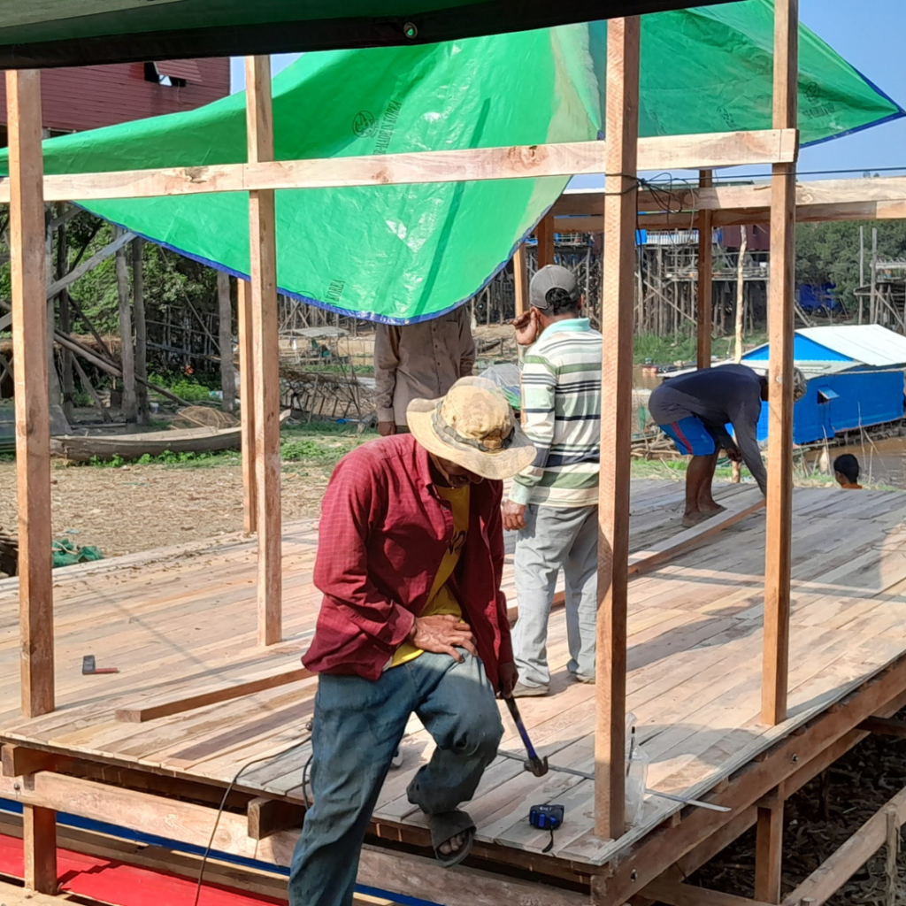DWC volunteer hammering on floor home Cambodia