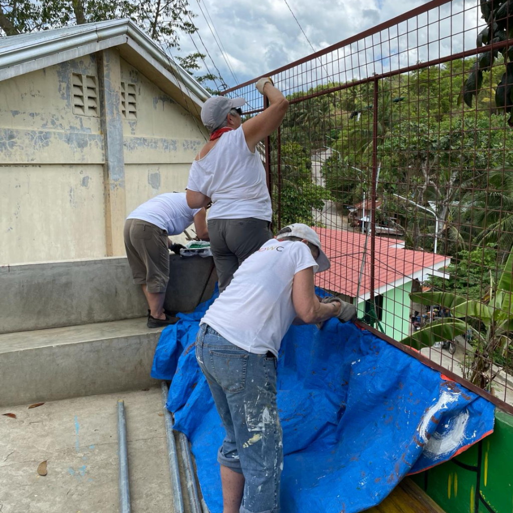 DWC volunteers painting security fence Philippines