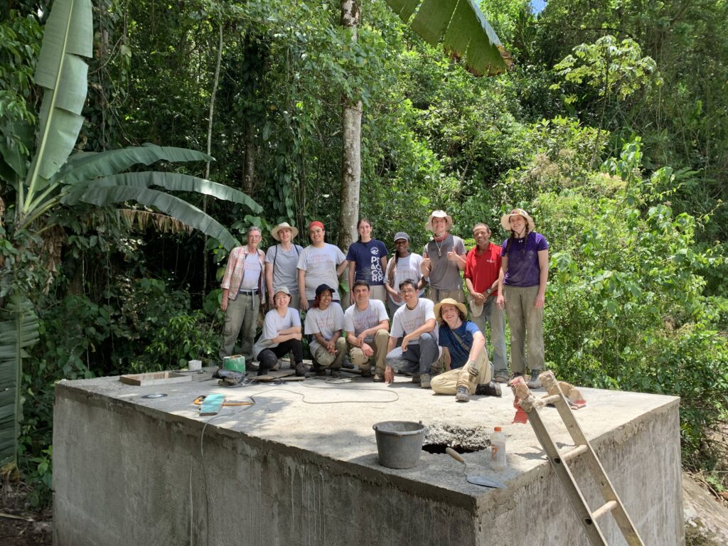 Volunteer group in Costa Rica posing on concrete water reservoir