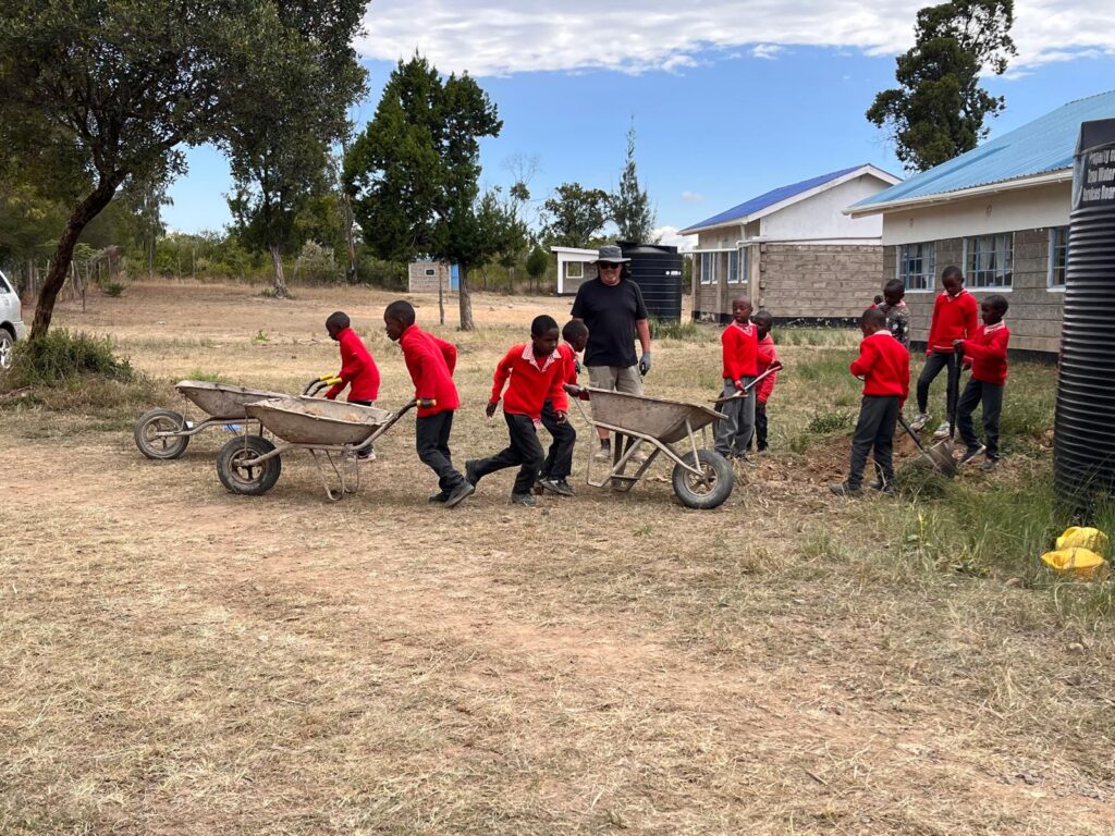 School kids using wheelbarrows Kenya