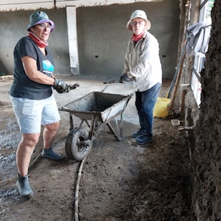 Volunteers putting mud on wall Kenya
