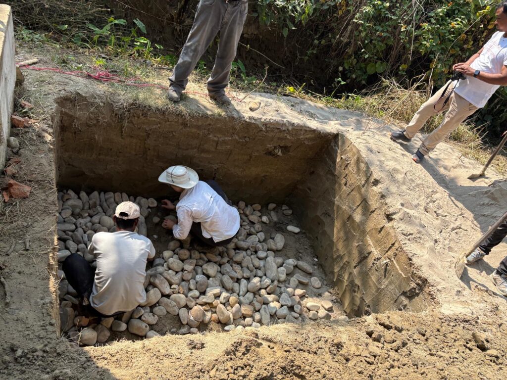 Volunteers placing rocks in pit Nepal