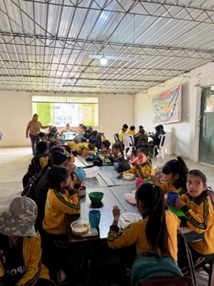 Peru school children eating breakfast at large table