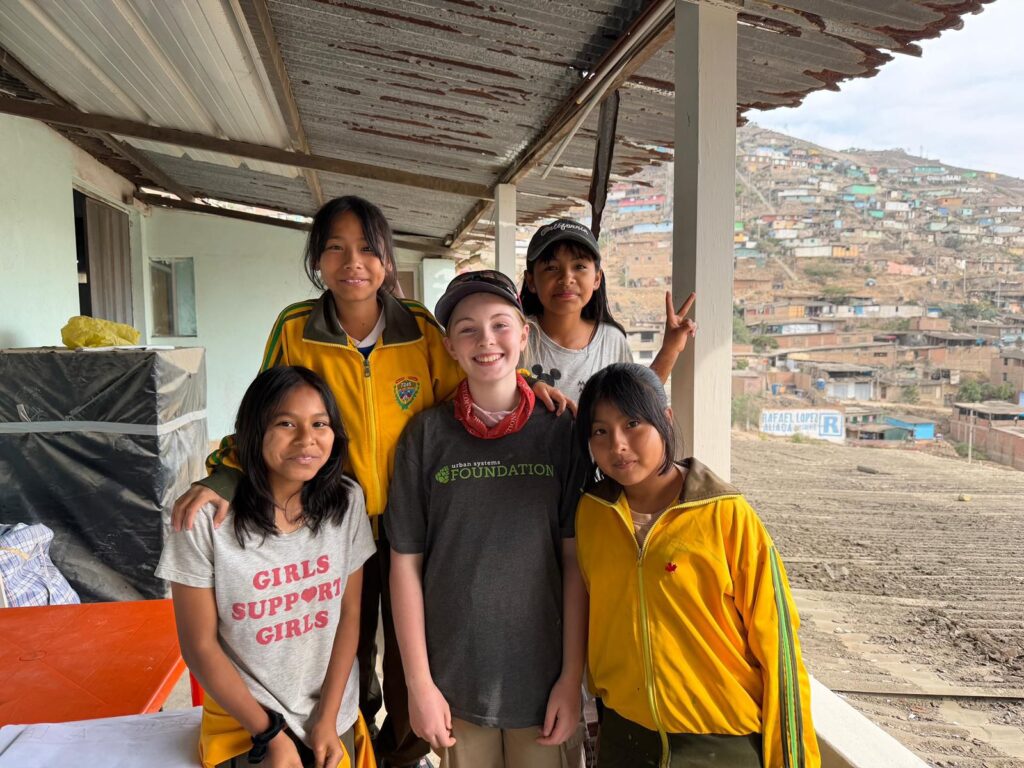 Volunteer posing with school girls Peru
