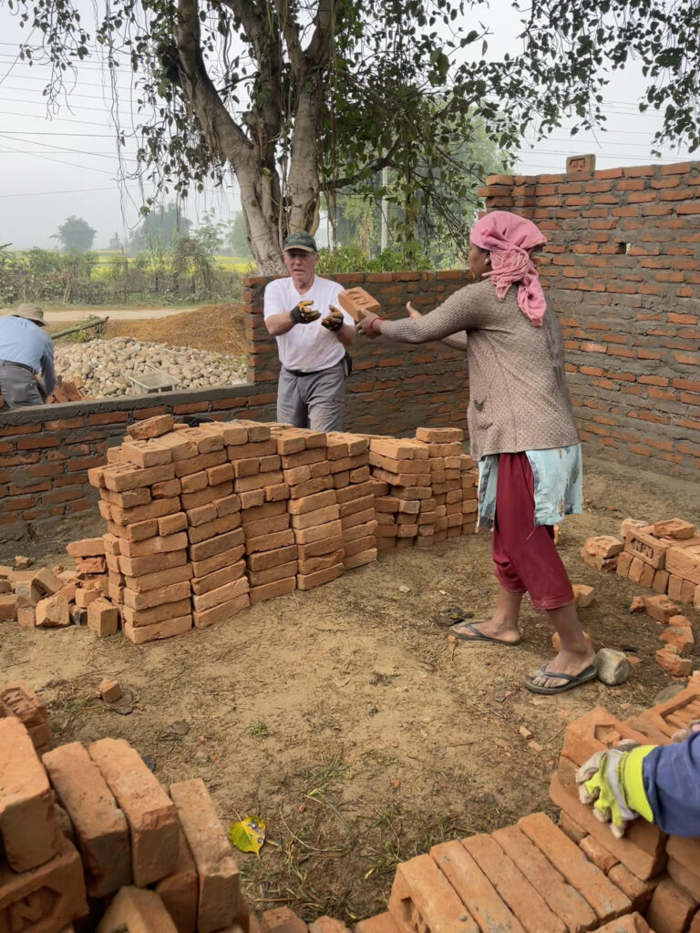 Volunteers in Nepal tossing bricks