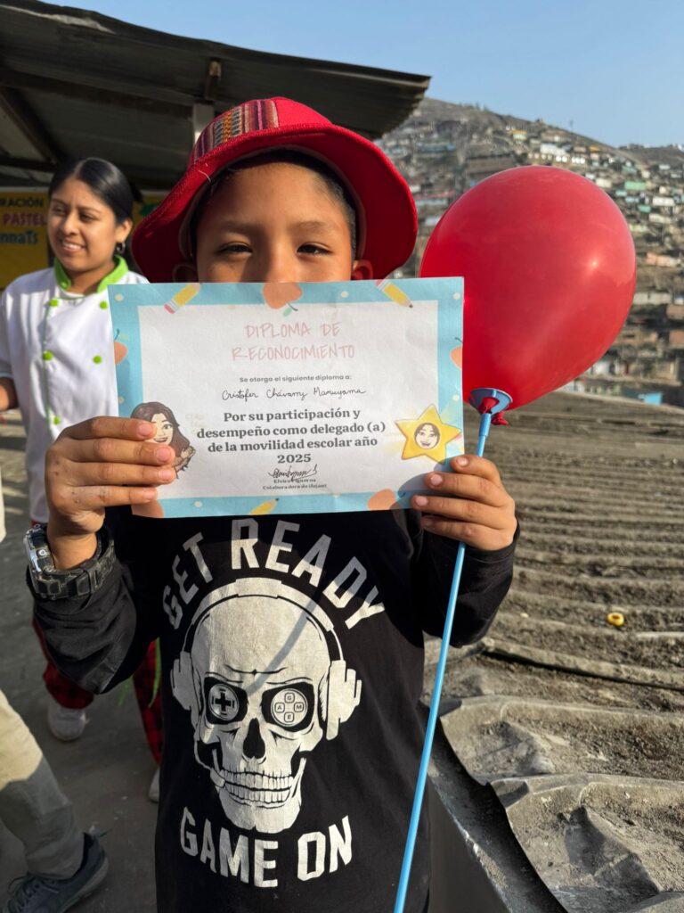 School boy showing diploma with balloon Peru